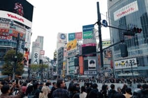 Crowds navigate the famous Shibuya Crossing, a hallmark of Tokyo's bustling urban life.
