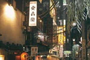 Illuminated Tokyo street with vibrant signs at night, showcasing urban Japan.