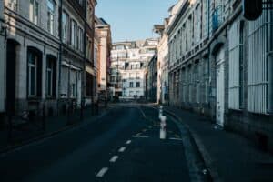 Empty alleyway flanked by historic buildings under a clear blue sky in a residential urban setting.
