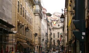 Discover the urban charm of Lisbon's historic streets with iconic tram, architecture, and vibrant life.