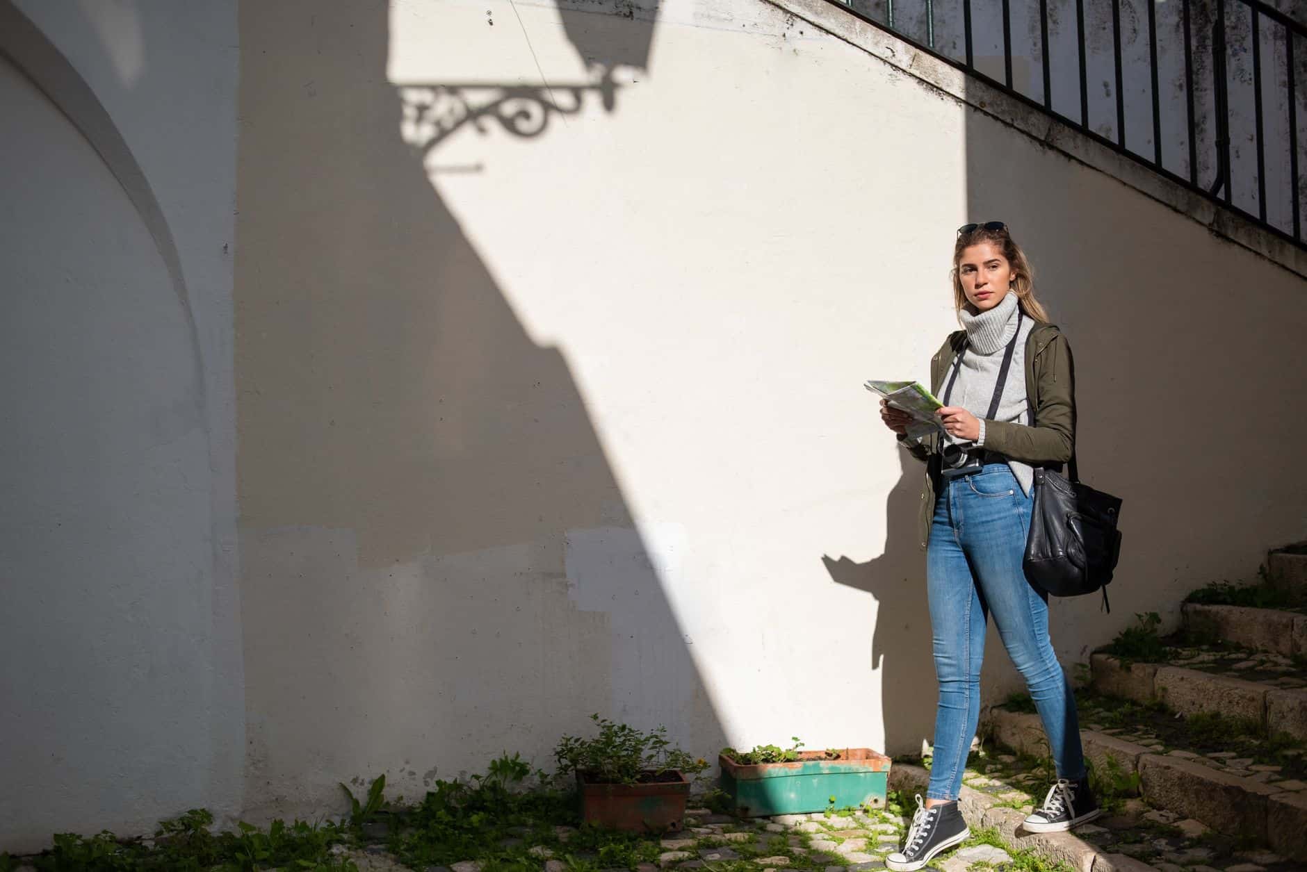 Woman with a map exploring a city street, embracing adventure and travel.