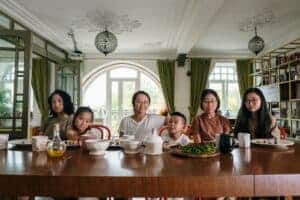 A diverse family enjoying dinner together in a cozy living room setting.