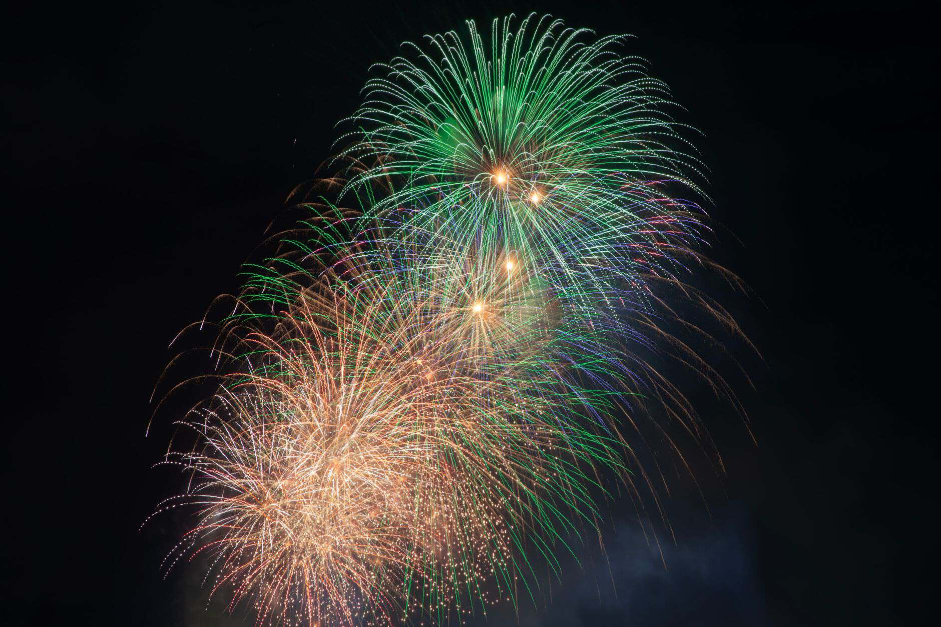 Colorful fireworks burst into the night sky, creating a vibrant and festive display.