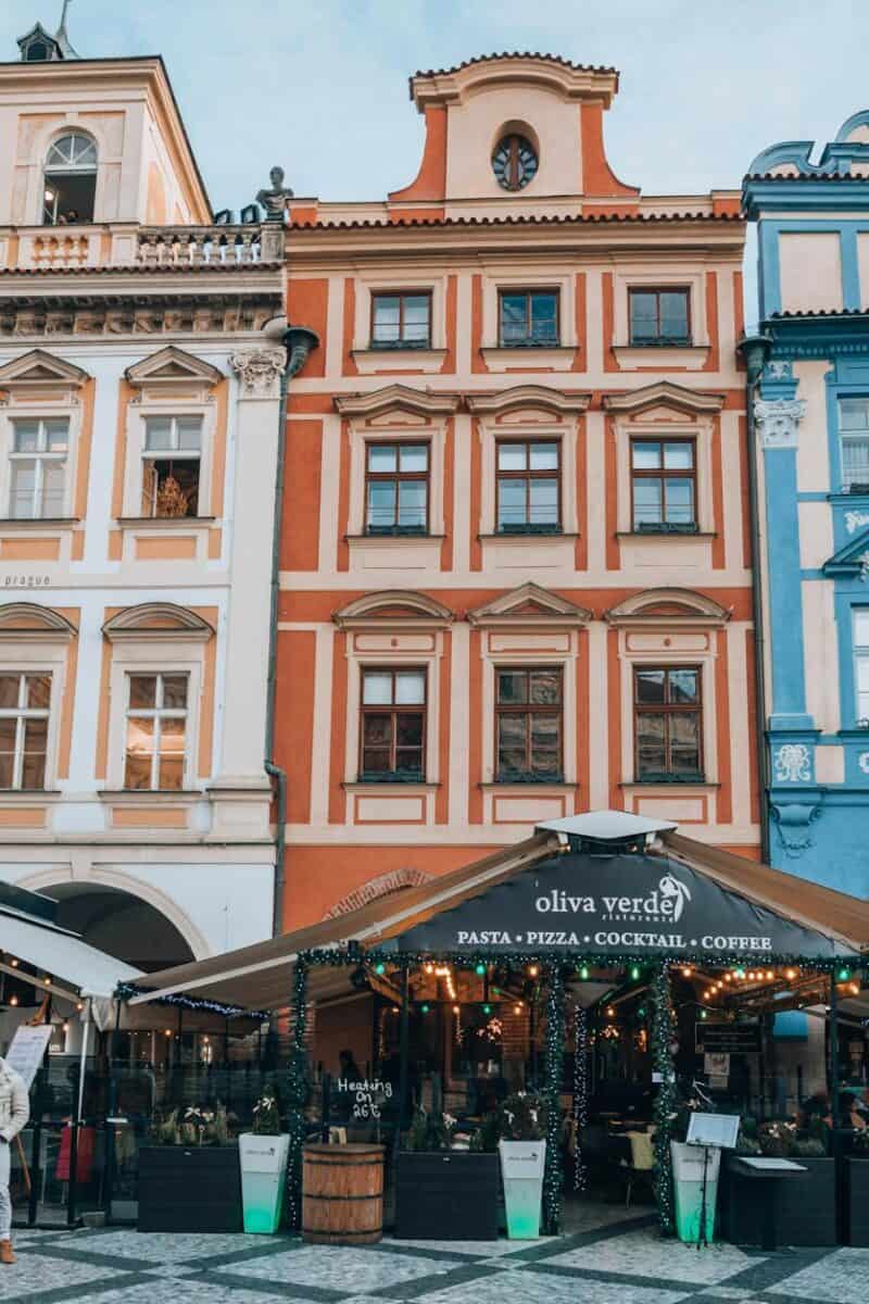 Charming European street with colorful facades and lively cafés bustling with people.