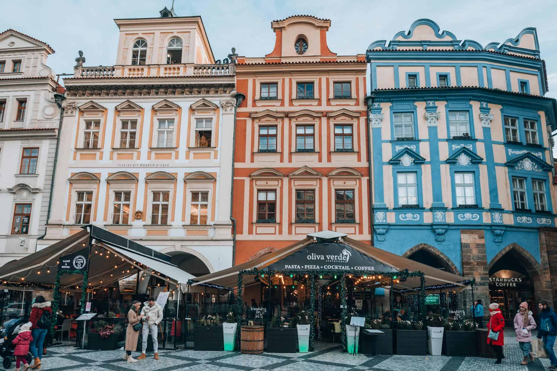 Charming European street with colorful facades and lively cafés bustling with people.