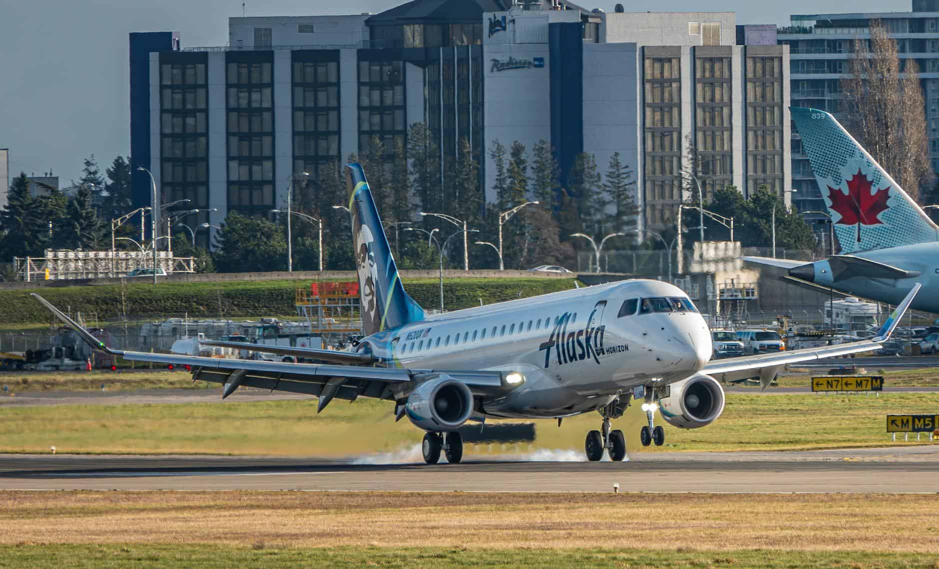 aircraft on the airport runway and buildings in background