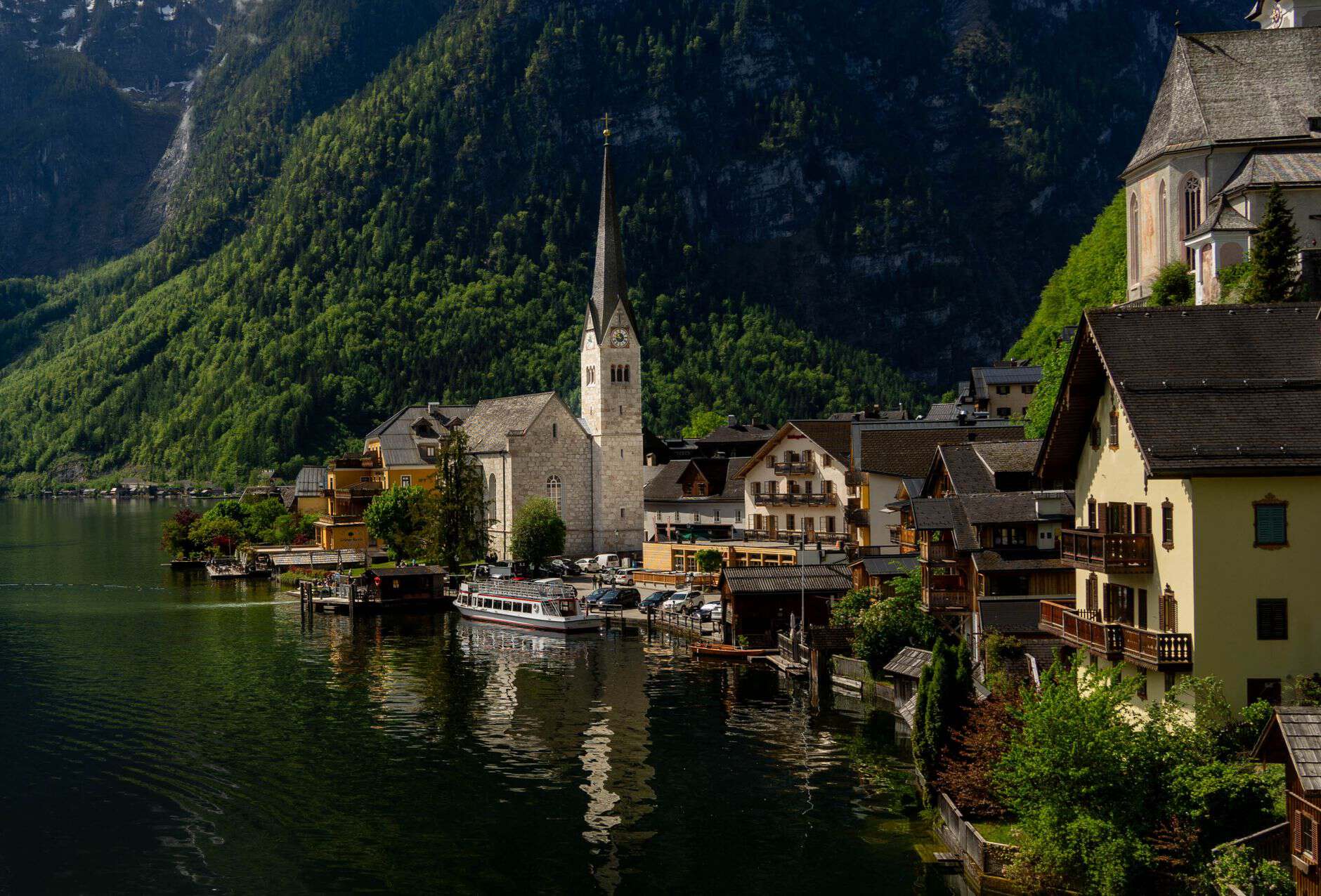 Charming view of Hallstatt with its iconic church by the lake against a backdrop of mountains.