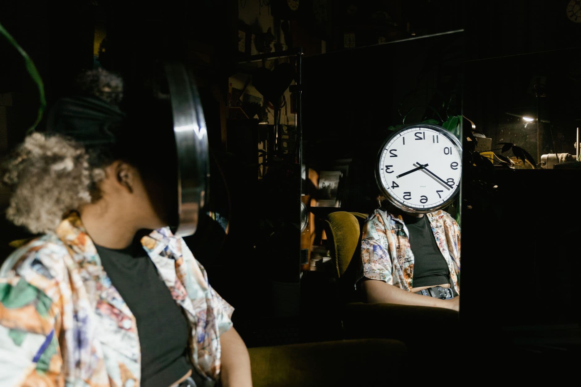 Artistic reflection of a woman with a clock replacing her face in a moody room.