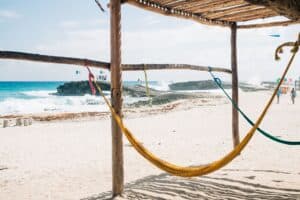 Person relaxing in a hammock on a quiet beach