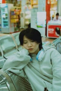 Tired traveler sitting in airport terminal with luggage after long flight