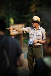 National park ranger at visitor center desk talking with tourists