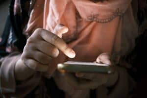 Person scrolling through phone with a contemplative expression
