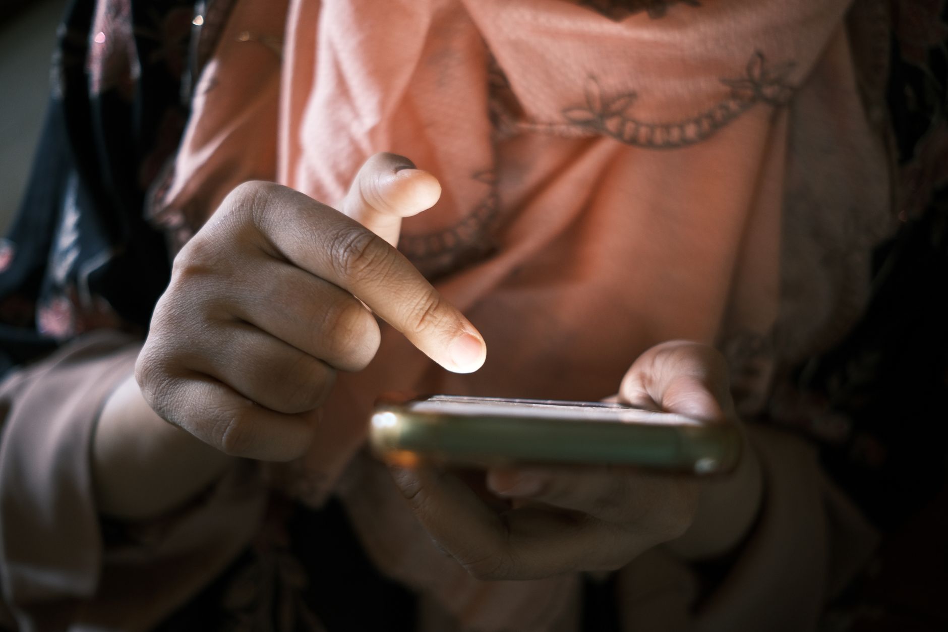 Person scrolling through phone with a contemplative expression