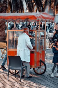 Street food vendor cart with travelers gathered at a night market