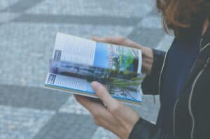 Traveler consulting a printed guidebook and local map