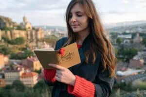Traveler writing in a journal during a reflective moment