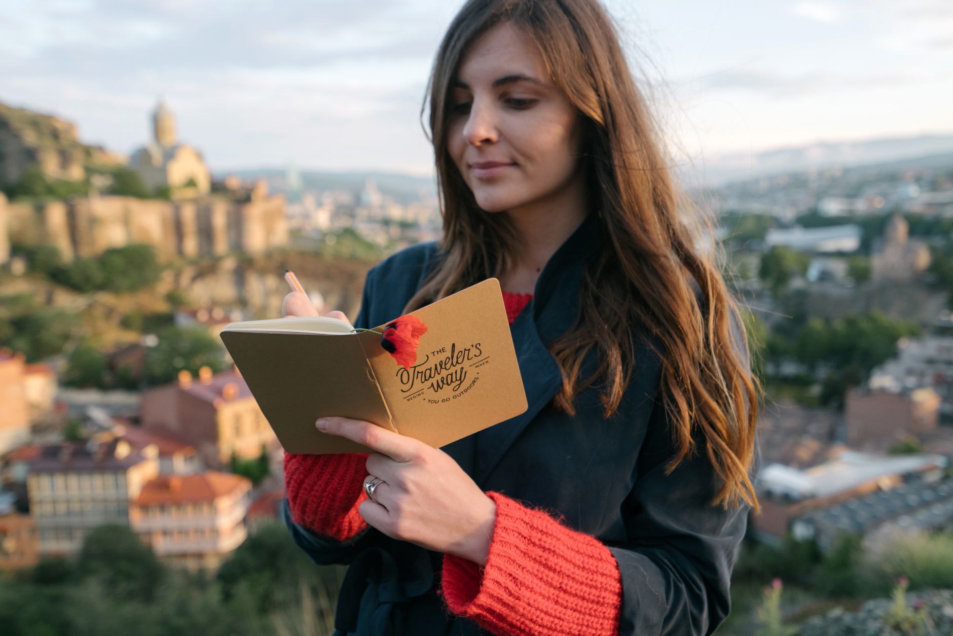 Traveler writing in a journal during a reflective moment
