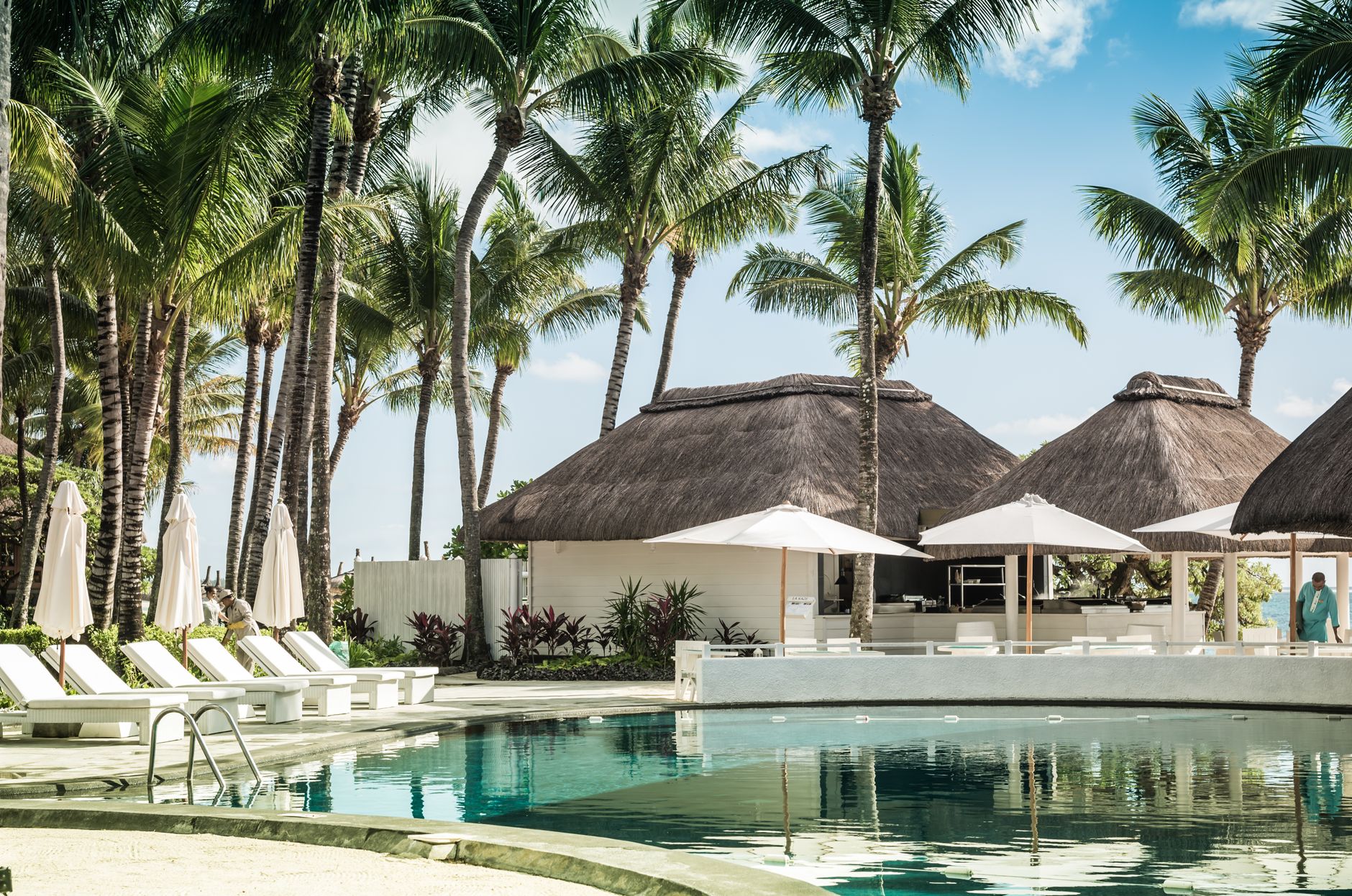 Traveler relaxing by resort pool with drink