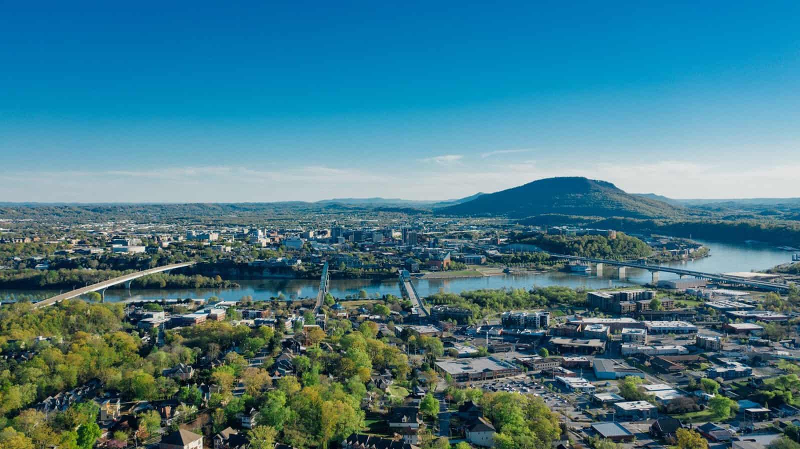 A stunning aerial view of Chattanooga, TN with the Tennessee River and scenic mountains.