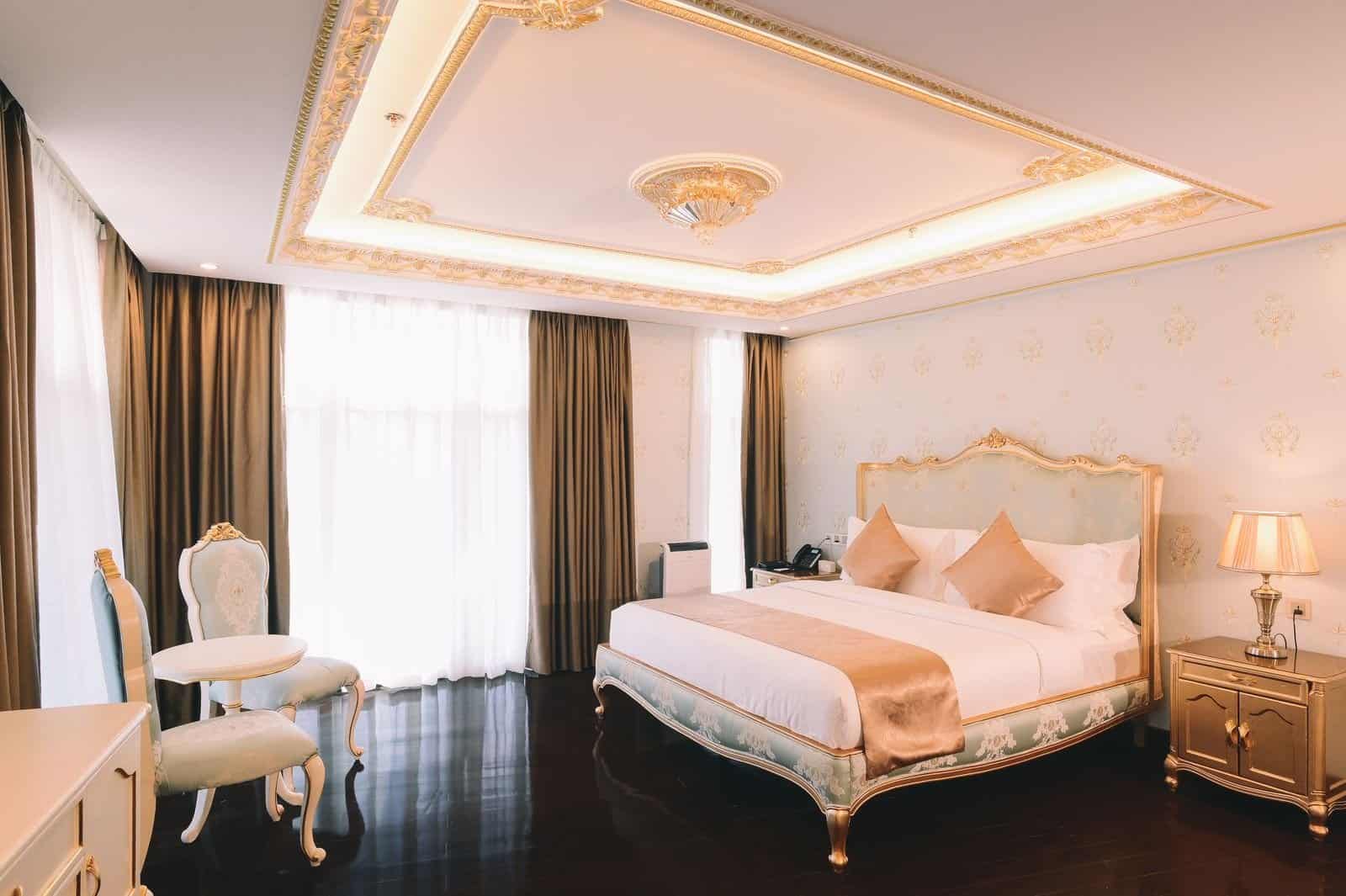 Luxury hotel room with a large bed and gold accents