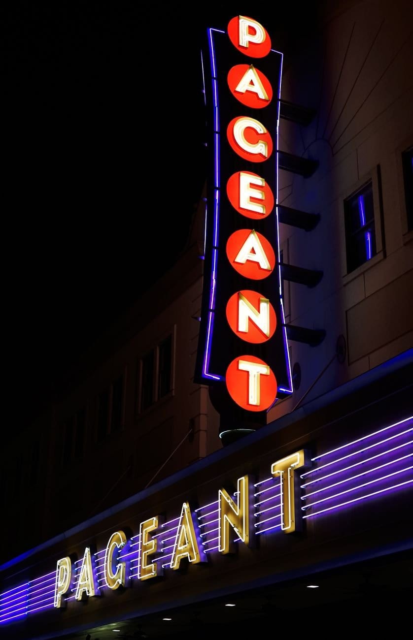 Vibrant neon sign of Pageant Theater in St. Louis illuminated at night.