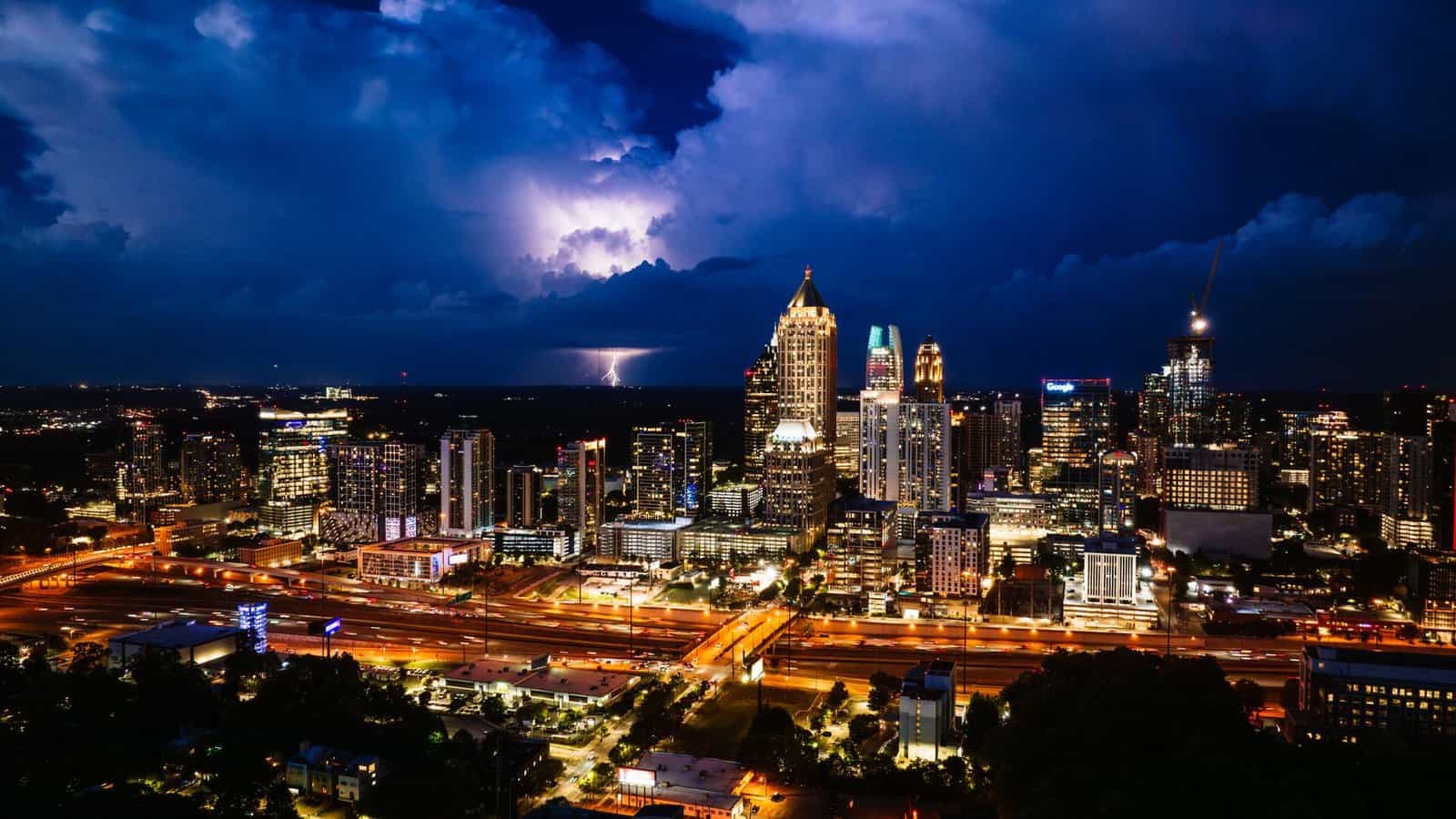 A vivid thunderstorm illuminates the Atlanta skyline at night, showcasing the city's vibrant urban landscape.