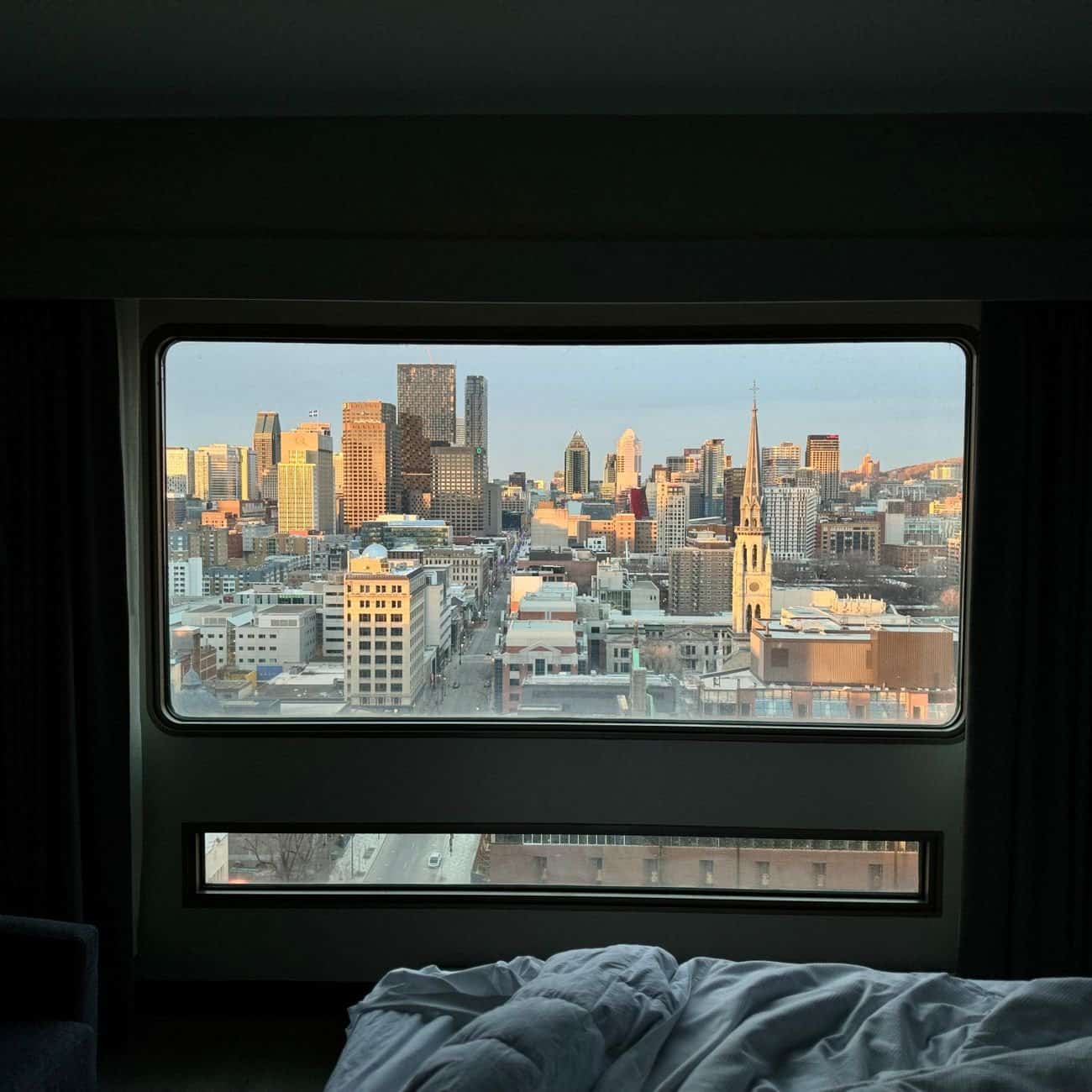 A beautiful city skyline view from a hotel room, framed by a large window.