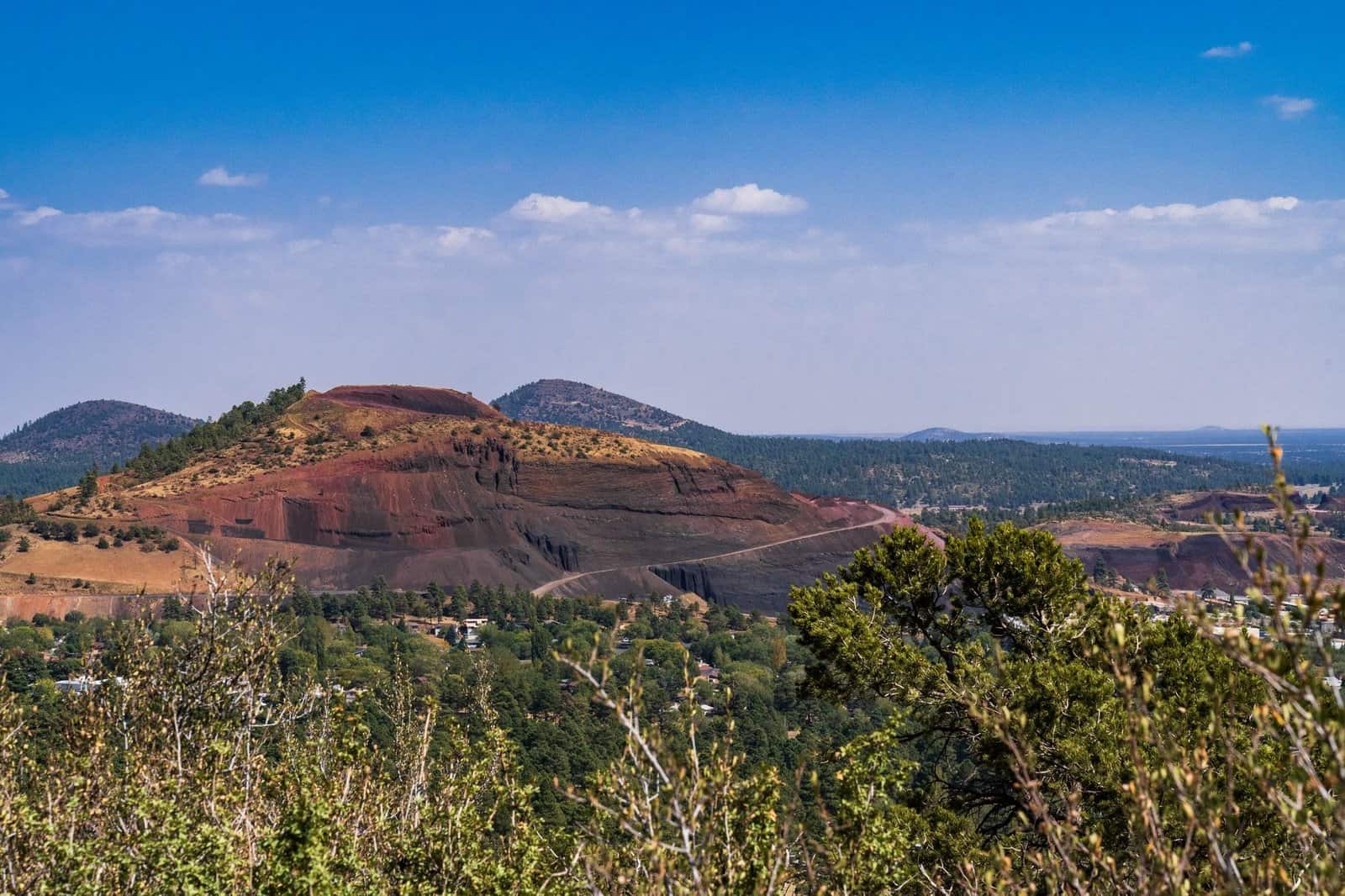 Scenic view of Red Cinder Cone with lush greenery under a clear blue sky in Flagstaff, Arizona.