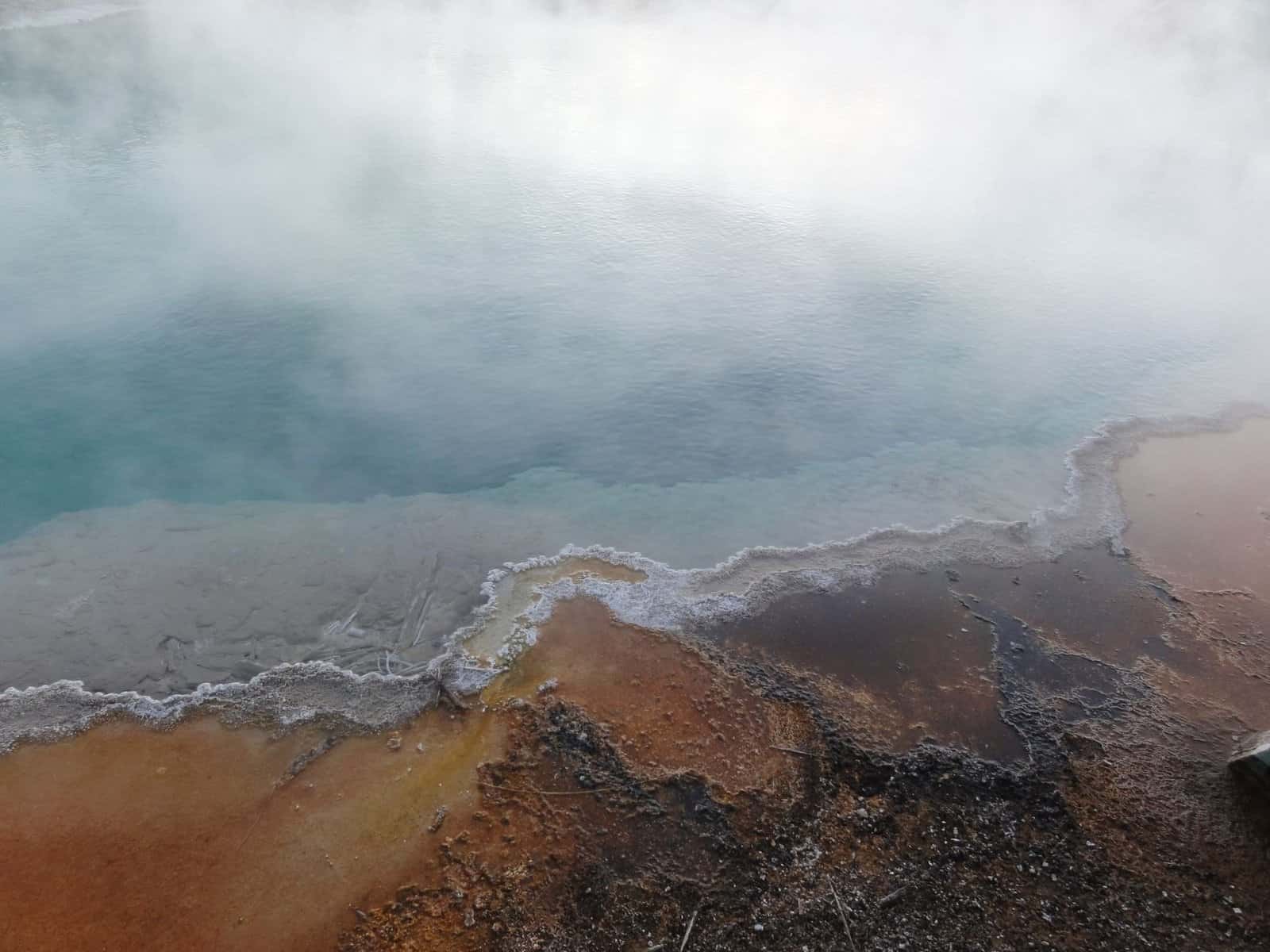 A mesmerizing view of a steaming geothermal pool in Yellowstone National Park, USA.