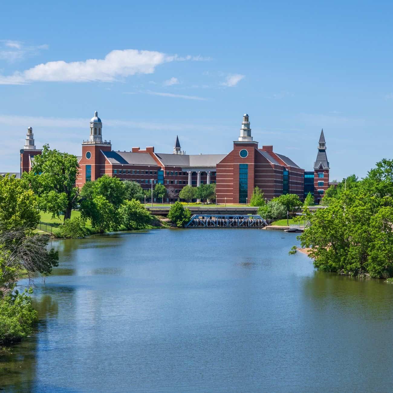 Scenic view of a university campus next to a river in Waco, Texas, with clear blue skies.