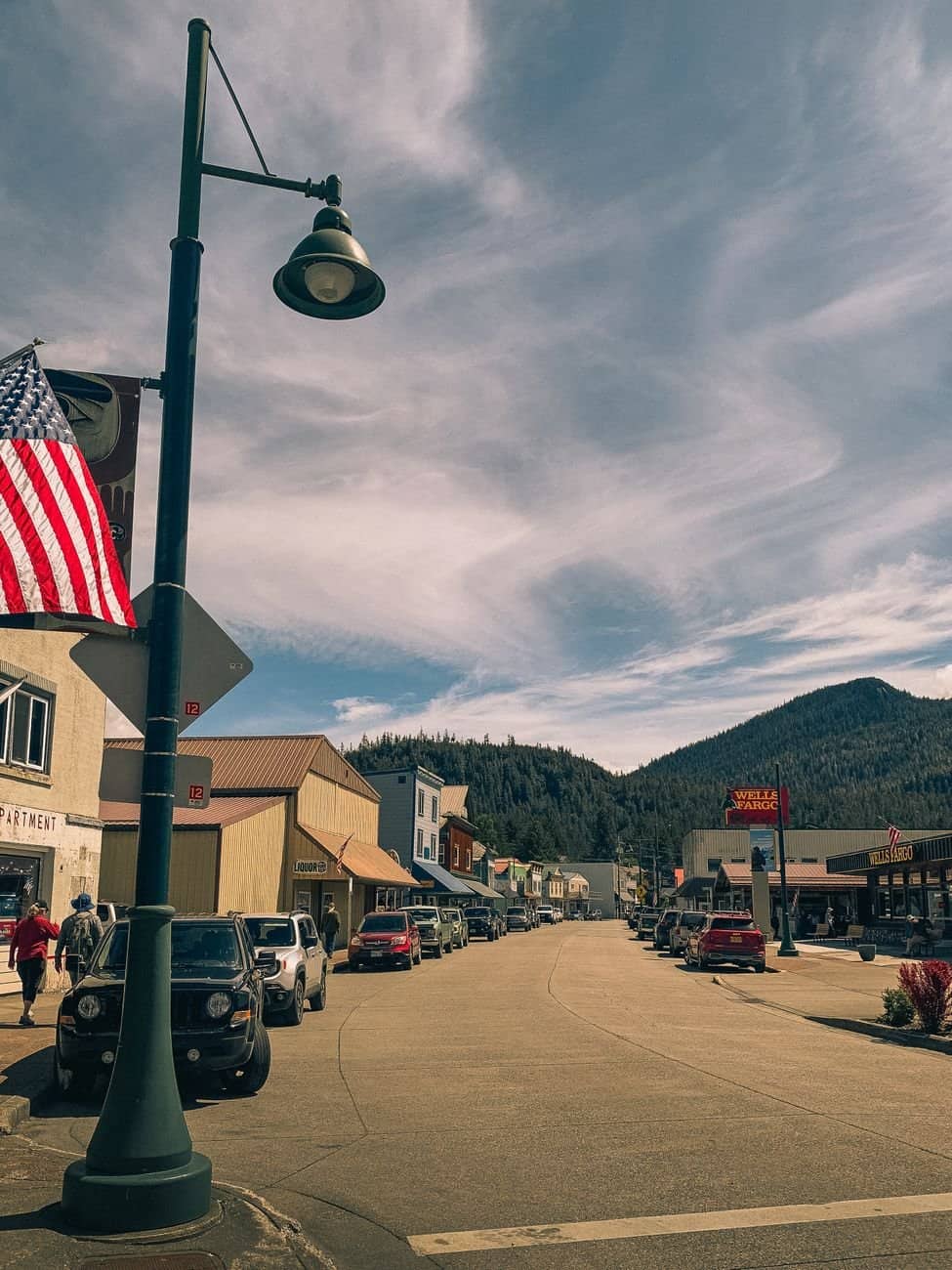 Explore a picturesque small town with a mountainous backdrop and vibrant street life captured in the daylight.