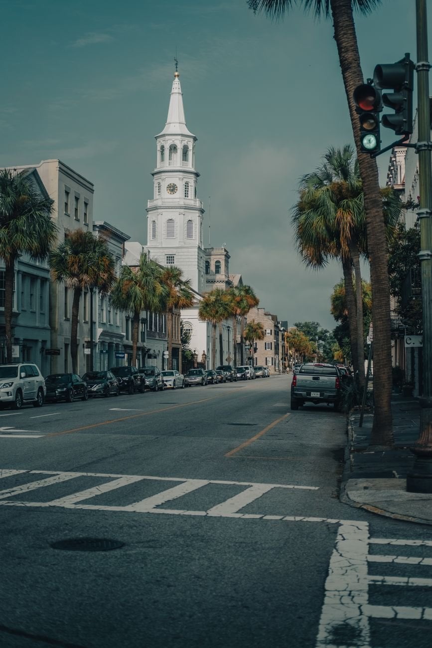 A serene city street view with Saint Michael's Church and palm trees in Charleston, South Carolina.