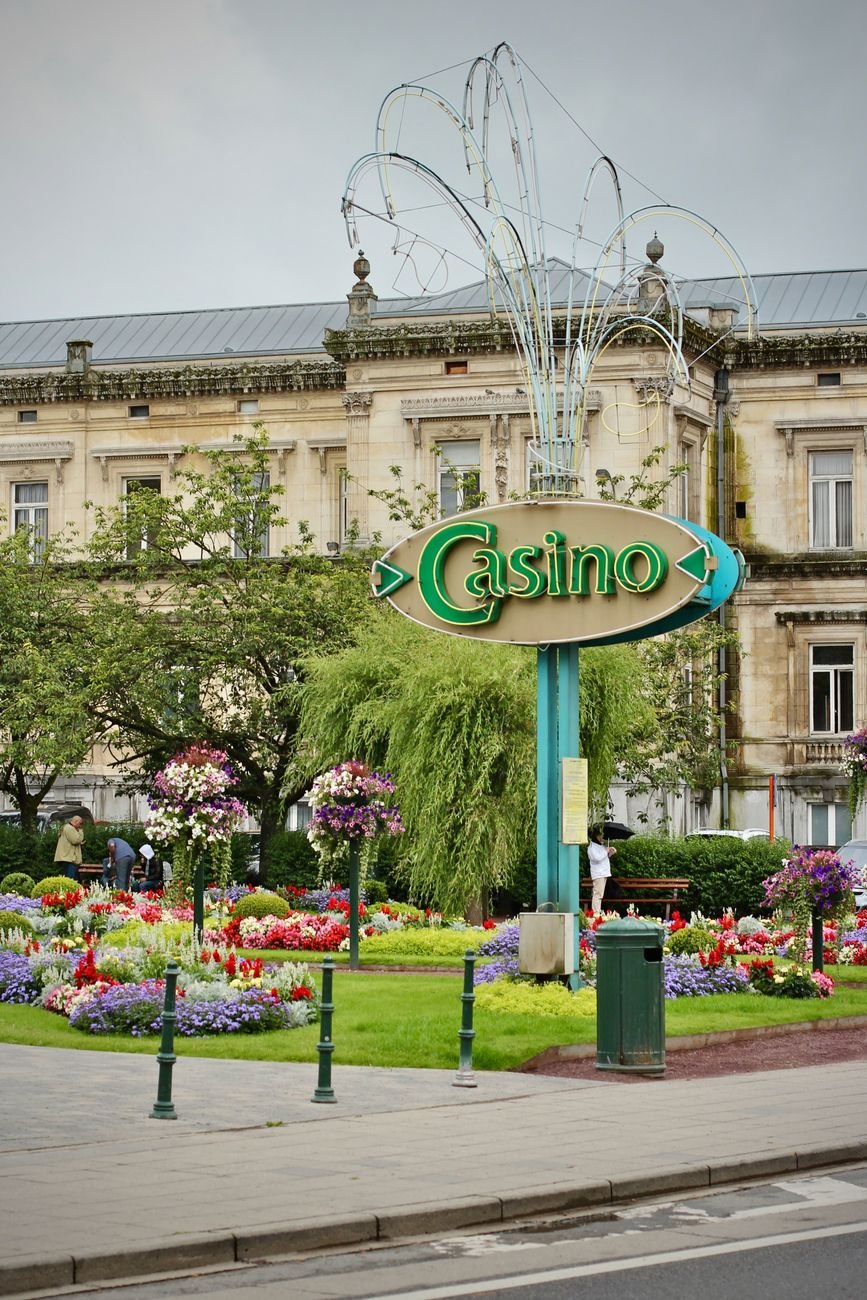 Charming casino entrance surrounded by vibrant flowers in a beautifully landscaped garden.
