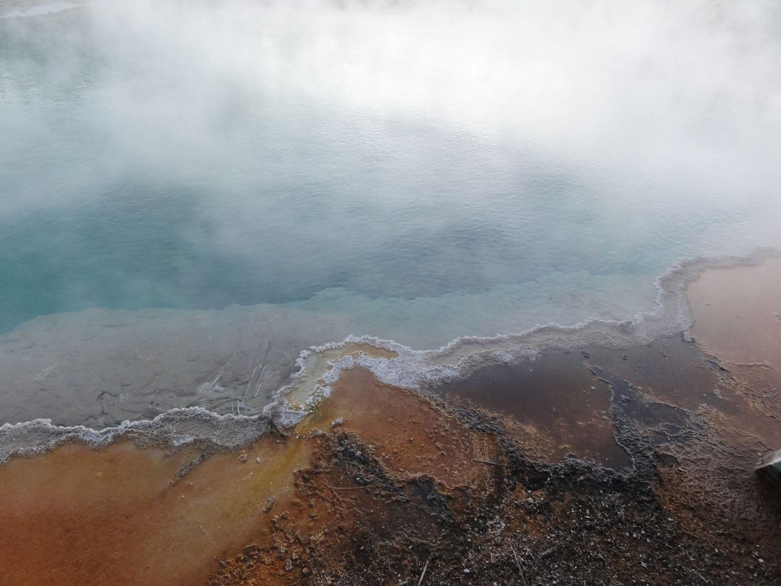 A mesmerizing view of a steaming geothermal pool in Yellowstone National Park, USA.