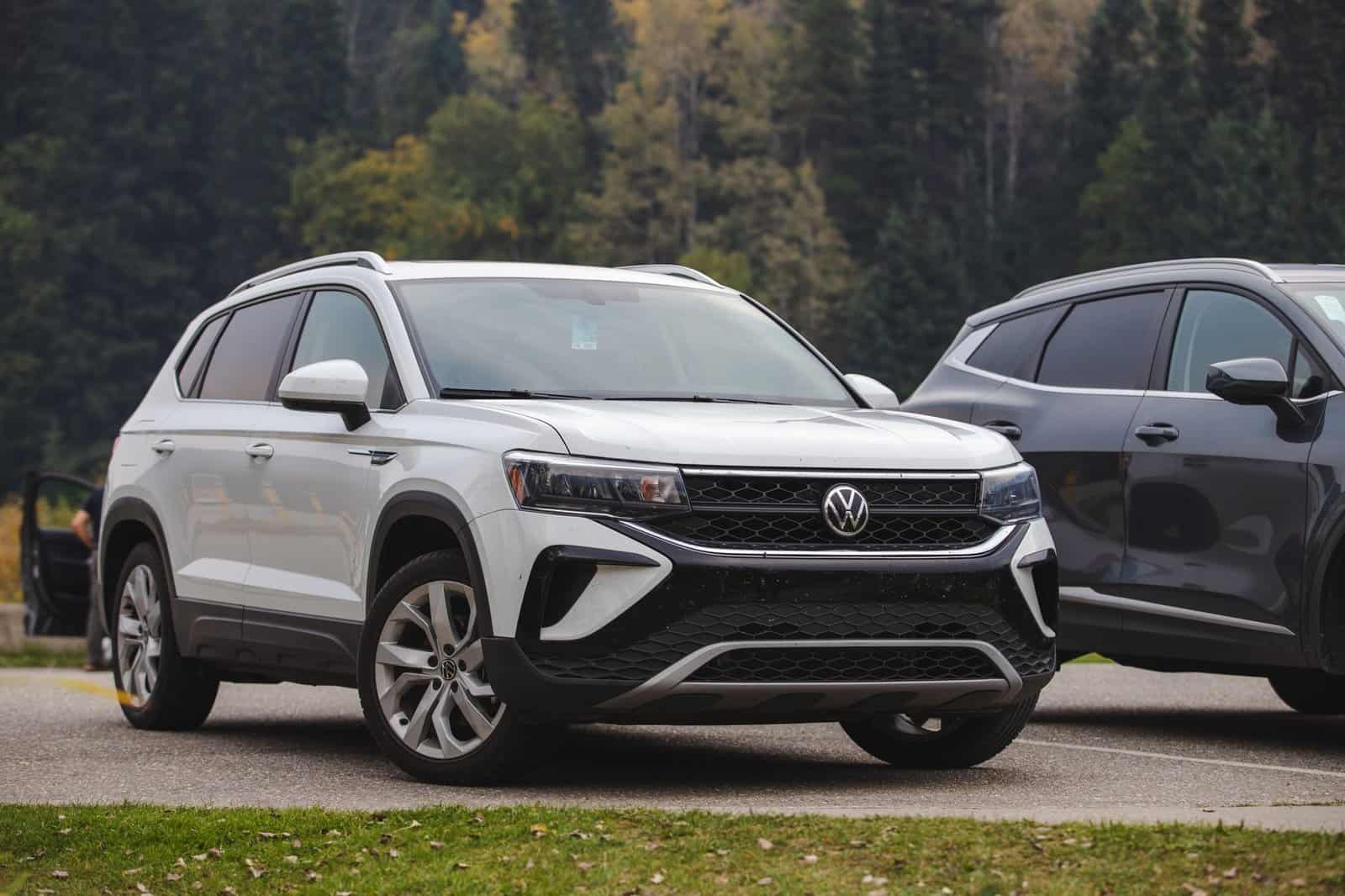 White Volkswagen compact SUV parked outdoors in a scenic forest setting.