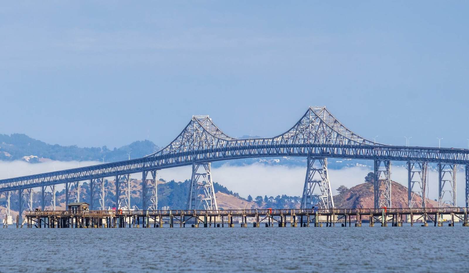 Clear view of the Richmond-San Rafael Bridge over tranquil waters under a blue sky.