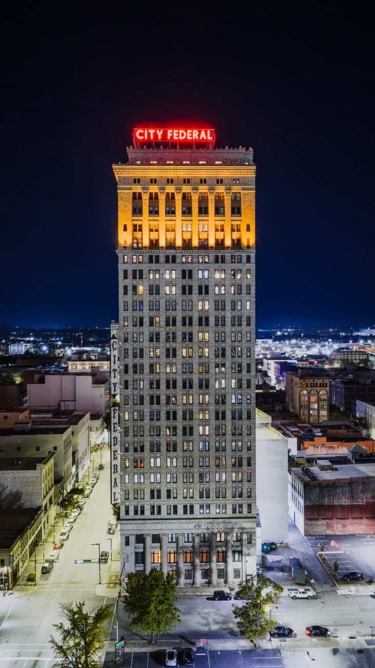 Aerial night view of the illuminated City Federal Building in Birmingham, Alabama.