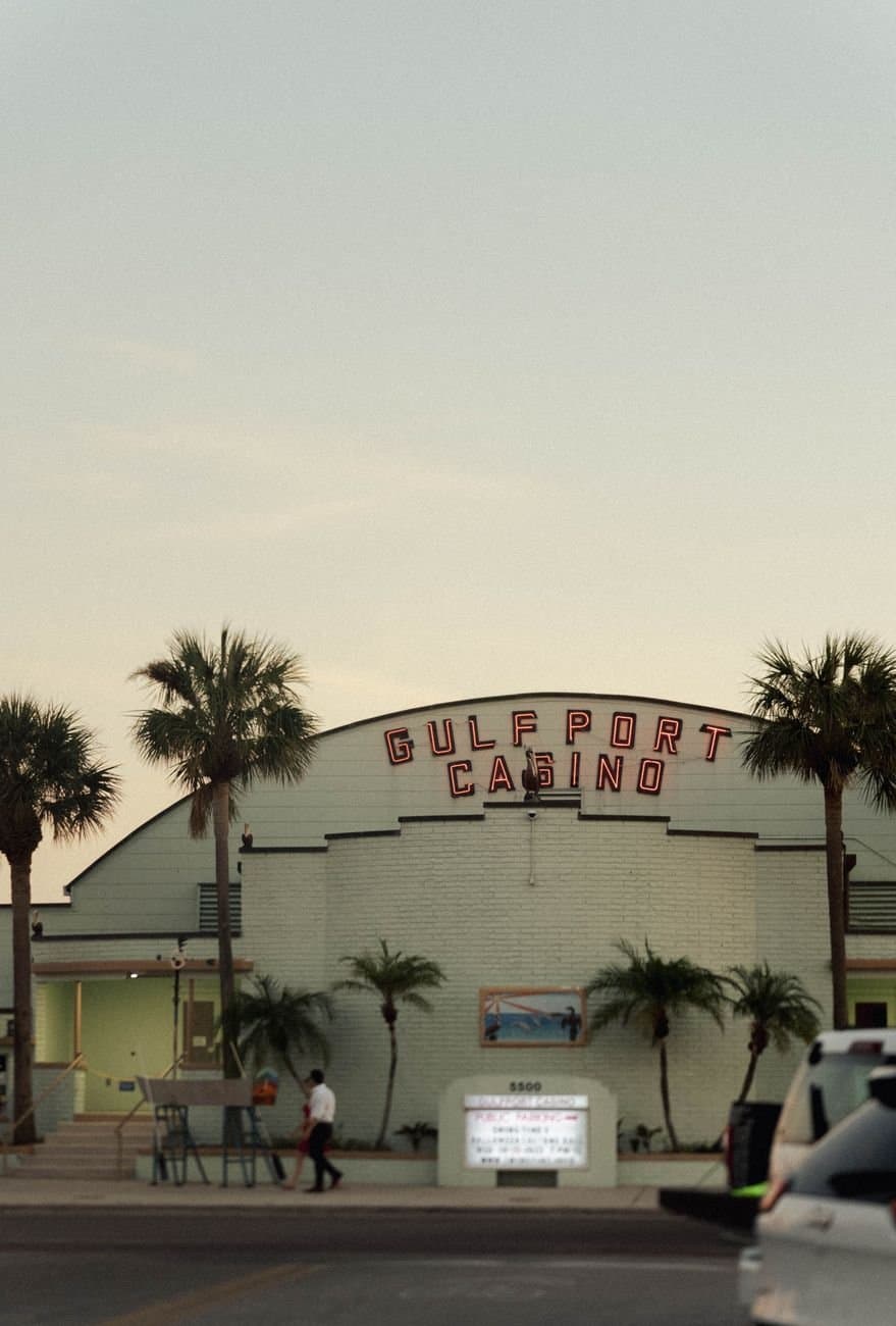 A view of the Gulfport Casino in Florida at sunset with palm trees.