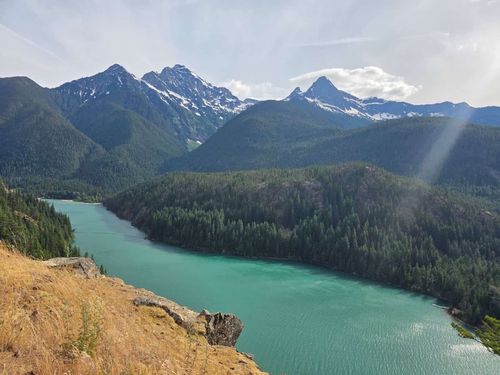A breathtaking view of Ross Lake surrounded by the Cascade Mountains under a clear sky.