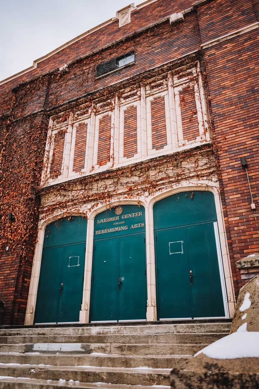 A vintage-style theater entrance with green doors and brick facade at the Performing Arts Center.