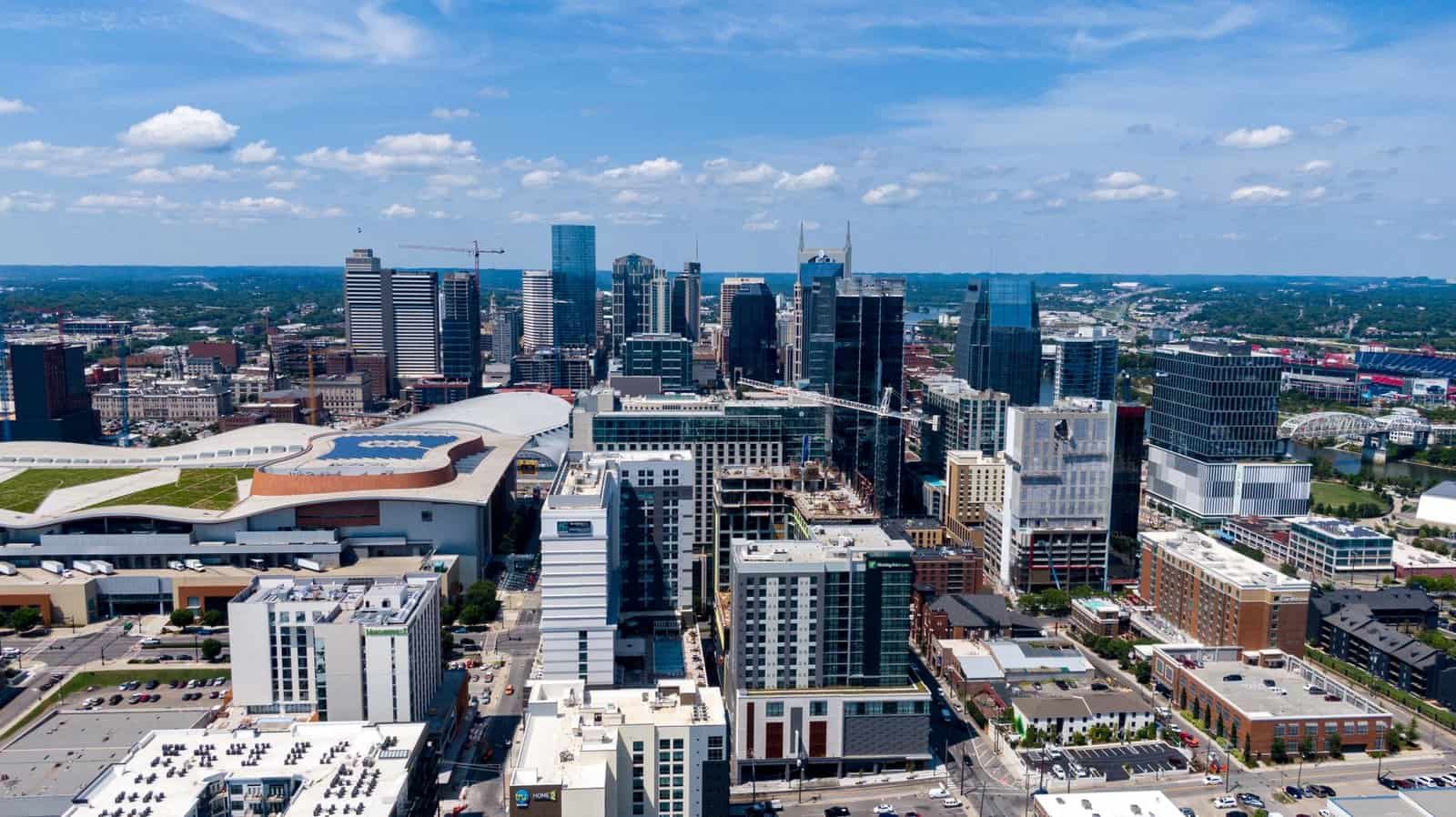 Aerial photo of Nashville skyline captured on a clear day with blue skies and modern skyscrapers.