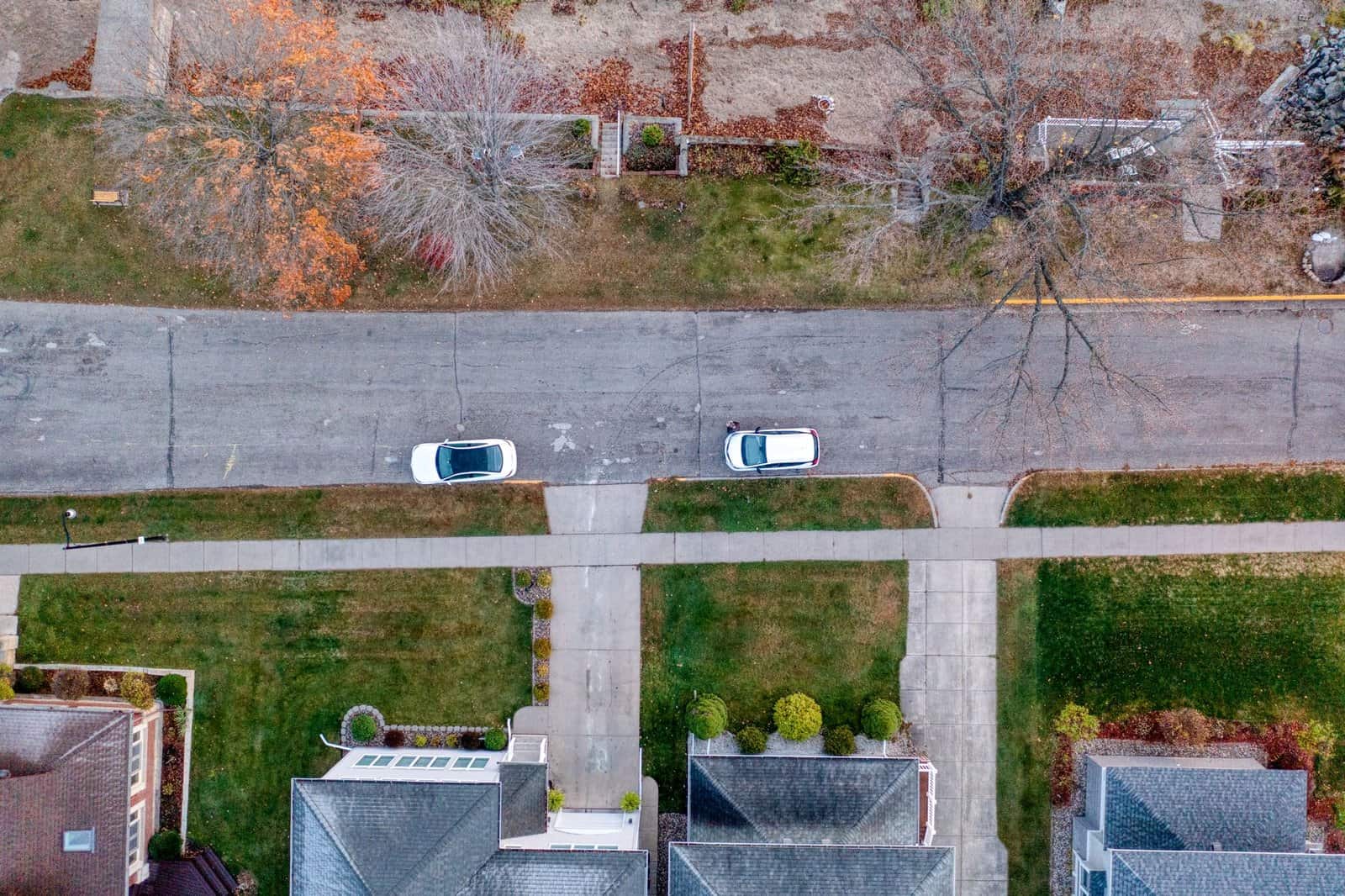 Aerial shot showing suburb street with parked cars, trees, and houses in Wabasha, Minnesota.