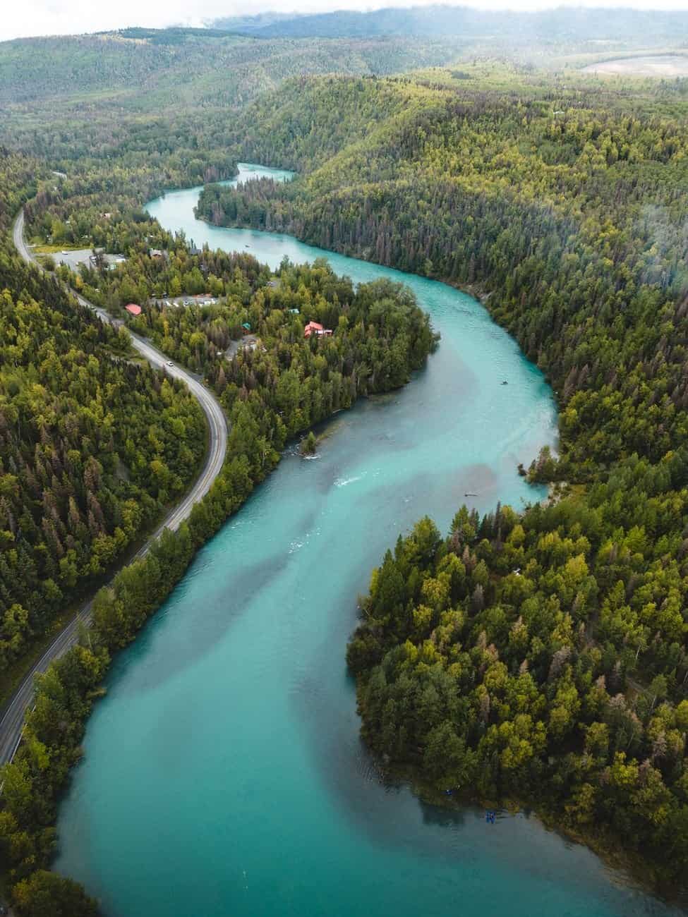 Captivating aerial shot of a winding river through vibrant forest landscapes in Cooper Landing, Alaska.