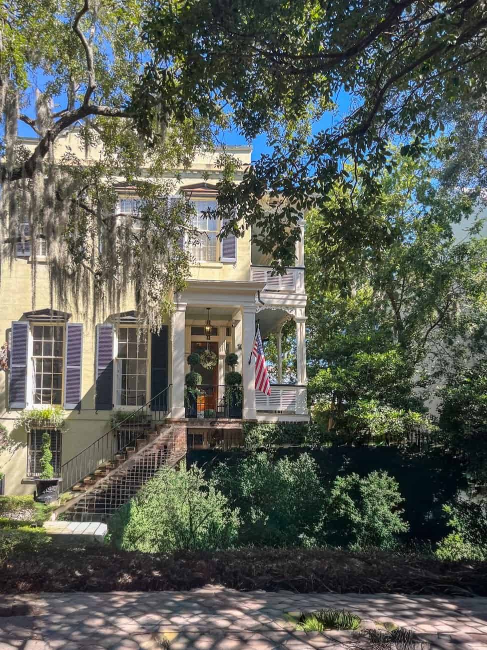 Charming Southern home with wrought iron stairs and American flag.