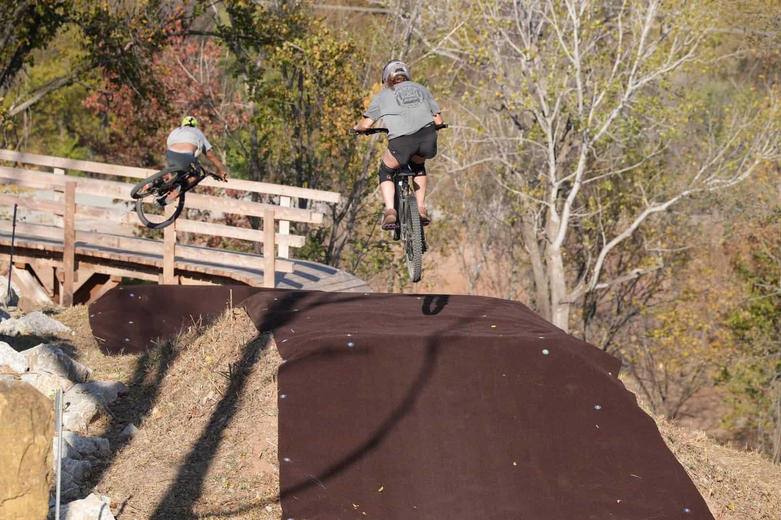 Two cyclists enjoying an exhilarating mountain biking session outdoors in a scenic autumn park.