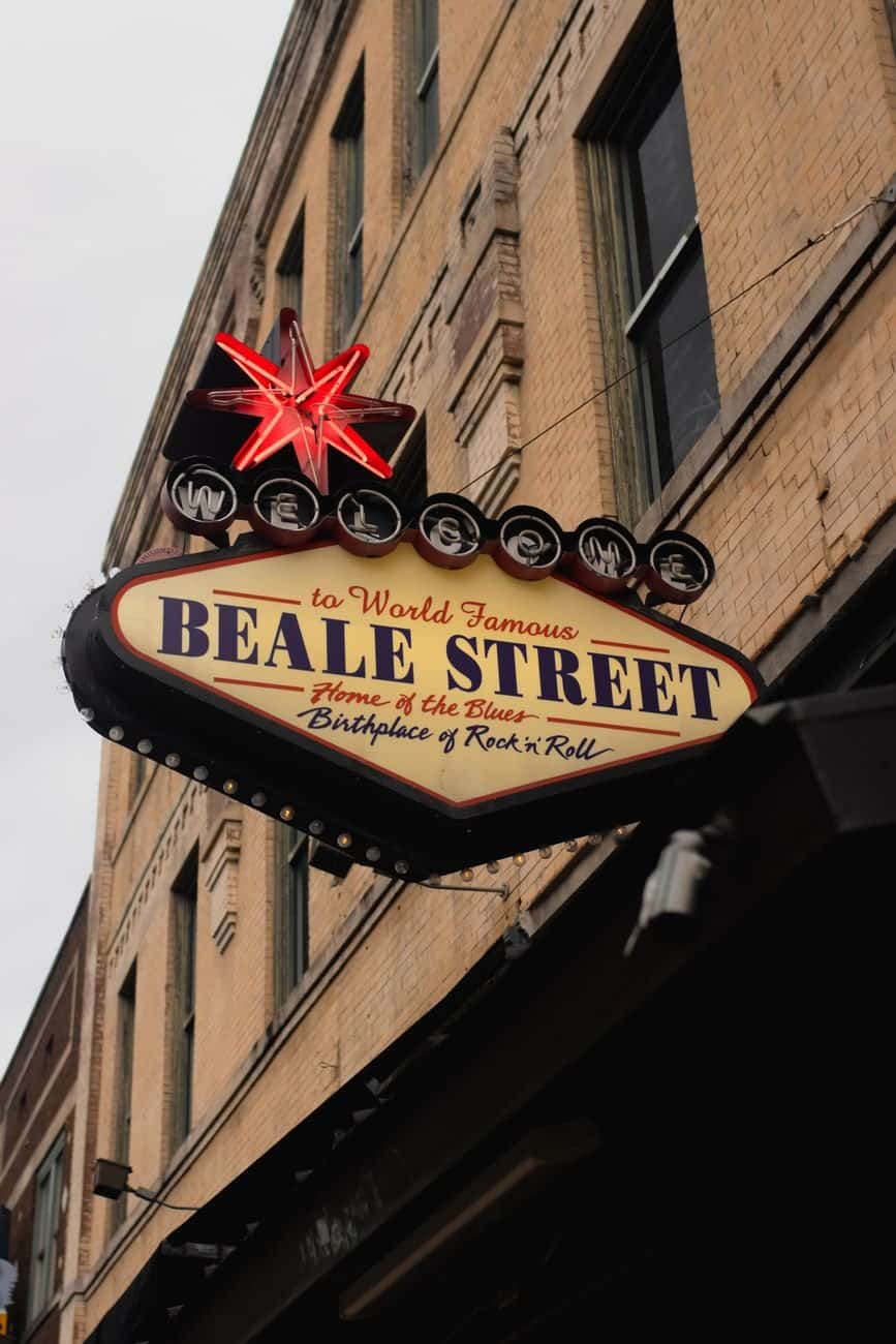 Iconic Beale Street neon sign in Memphis, birthplace of blues and rock 'n' roll in bustling urban setting.
