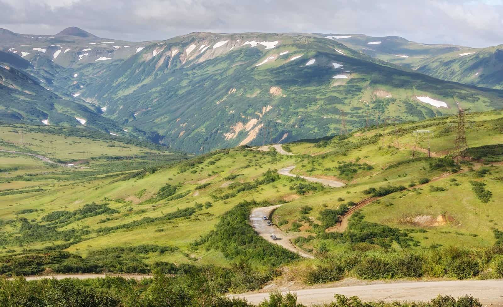 Breathtaking mountain landscape featuring a scenic road amidst lush greenery, perfect for nature escapes.