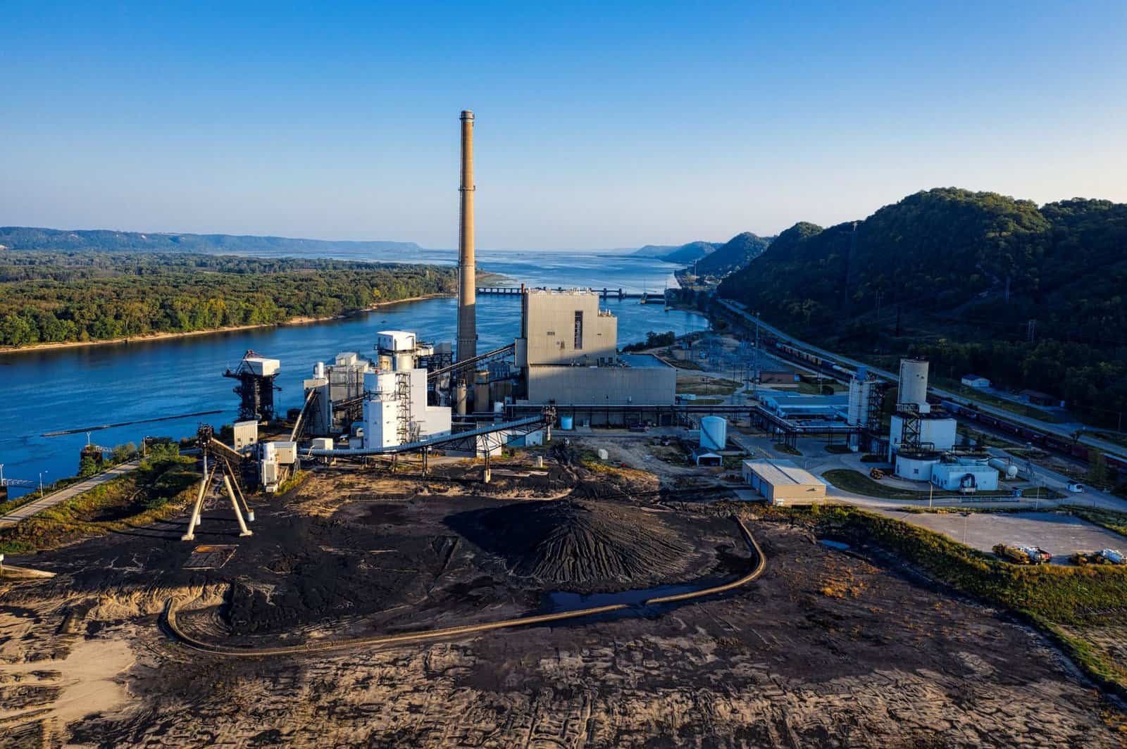 Aerial view of an industrial facility by a river in Genoa, WI, showcasing environmental impact.