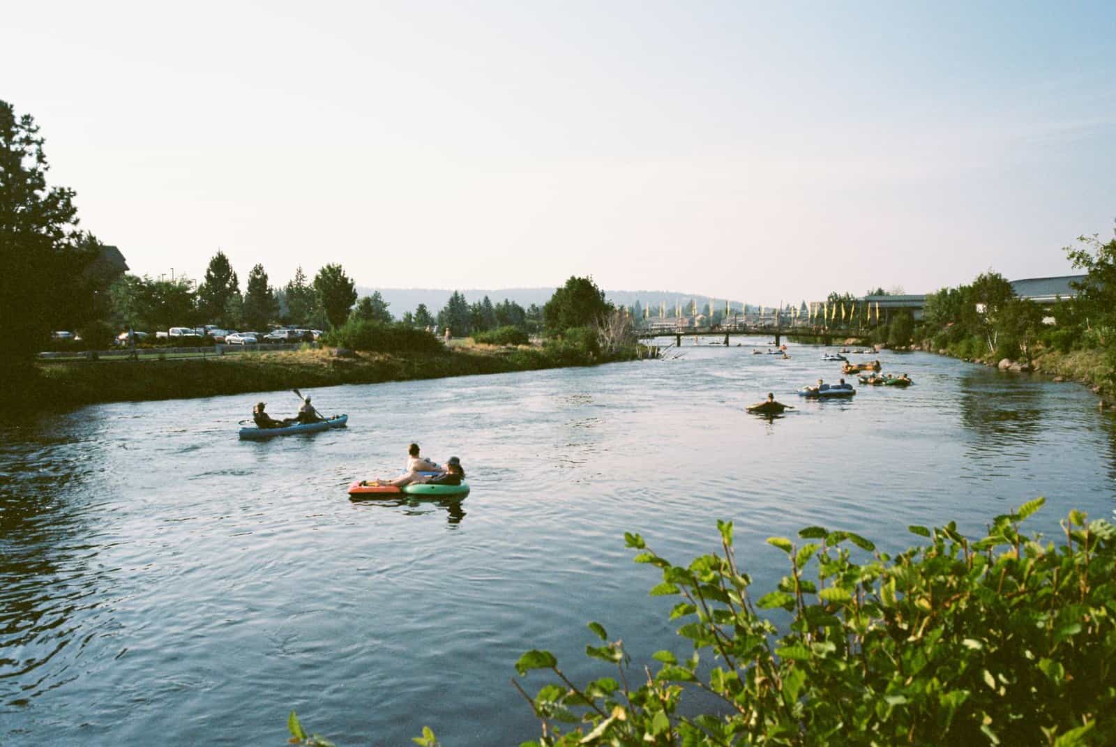People enjoying a sunny day kayaking on the scenic Deschutes River in Bend, Oregon.