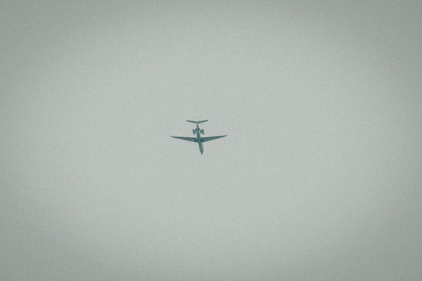 A lone airplane captured mid-flight against a cloudy sky, symbolizing travel and adventure.